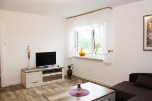 a living room with a tv and a table at Ferienwohnung Klein Süstedt in Klein Süstedt