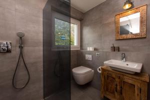 a bathroom with a shower and a toilet and a sink at Matterhorn Panorama Apartment in Zermatt +16 photos