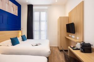 a hotel room with two beds and a tv at Hôtel Byakko Nice in Nice