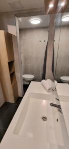 ein Badezimmer mit einem weißen Waschbecken und einer Toilette in der Unterkunft Malinki Apartment in Ålesund + 1 Foto