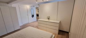 ein Zimmer mit weißen Schränken und einer Kommode darin in der Unterkunft Malinki Apartment in Ålesund
