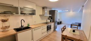 eine Küche mit Spüle und Tisch in einem Zimmer in der Unterkunft Malinki Apartment in Ålesund