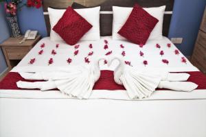 a bed with two swans making a heart at Elite Beach Inn in Hulhumale