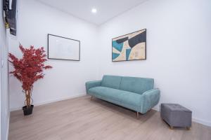 a living room with a blue couch and a plant at A Casa da Luísa in Vila Real