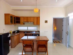 a kitchen with a wooden table and a refrigerator at Bo-Box Guesthouse & Female Only Capsule Lempuyangan - Khusus Wanita in Yogyakarta