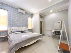a bedroom with a large bed and a desk at Bo-Box Guesthouse & Female Only Capsule Lempuyangan - Khusus Wanita in Yogyakarta