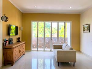 a living room with a couch and a large window at Bo-Box Guesthouse & Female Only Capsule Lempuyangan - Khusus Wanita in Yogyakarta