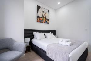 a hotel room with a bed and a chair at A Casa da Luísa in Vila Real +70 photos