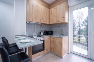 a kitchen with wooden cabinets and a large window at A Casa da Luísa in Vila Real