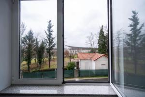 an empty room with two large windows looking out at a house at A Casa da Luísa in Vila Real