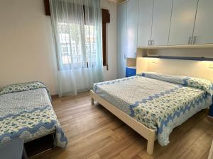 a bedroom with two beds and a window at Appartamenti Mare Caorle in Caorle +52 photos