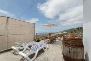 a patio with a table and chairs and a barrel at El Barril in Chio
