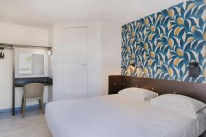a bedroom with a white bed and a blue and white wall at Fasthotel Angers Beaucouzé in Beaucouzé