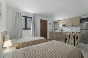 a bedroom with two beds and a small kitchen at El Barril in Chio