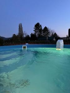 a large pool of blue water with two objects in it at DIÓFA APARTMAN in Pilismarót +20 photos