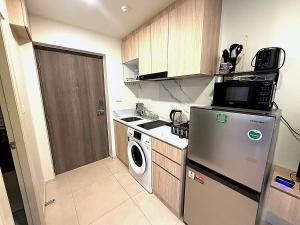 a small kitchen with a refrigerator and a washer at Modern Apartment with Queen Bed in Living Room & Separate Bedroom in Lamai