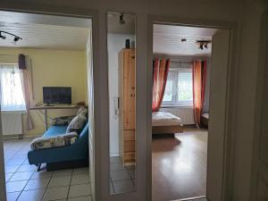 ein Zimmer mit einem Wohnzimmer, ausgestattet mit einer Couch und einem Fernseher in der Unterkunft Hildegard in Usingen