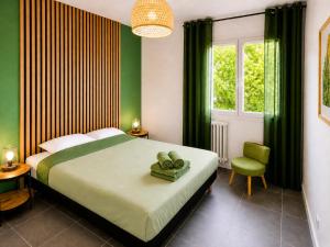 a bedroom with a large bed and a green wall at " Souffle Vert " Wifi - TV - 4 personnes in Muret +22 photos