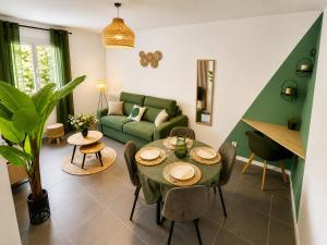 a living room with a green couch and a table at " Souffle Vert " Wifi - TV - 4 personnes in Muret