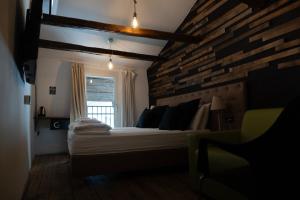 a bedroom with a bed and a brick wall at Sir Thomas Bed Central in Bolzano