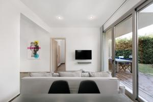 a living room with a white couch and a tv at SunBlue Boutique Villas in Skala Rachoniou