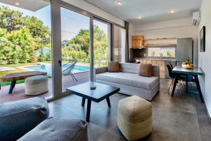 a living room with a couch and a table at SunBlue Boutique Villas in Skala Rachoniou