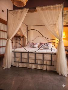 a bedroom with a canopy bed with mosquito netting at Casa rural con piscina cubierta en Segovia - Viento de Ladera in Segovia +17 photos