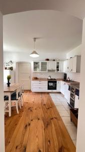 a kitchen with white cabinets and a wooden floor at Statek Bavorov in Bavorov +10 photos