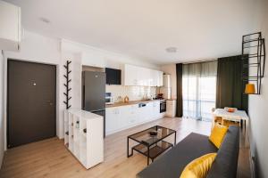 a living room with a couch and a kitchen at FLH - Sunset Horizon near Shopping City with parking in Şelimbăr