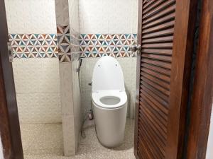 a bathroom with a white toilet in a stall at Noahs Ark Beach in Nathon Bay