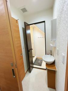 a bathroom with a toilet and a sink and a mirror at K-House in Tokyo