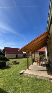 a wooden pergola with a table and chairs in a yard at Statek Bavorov in Bavorov