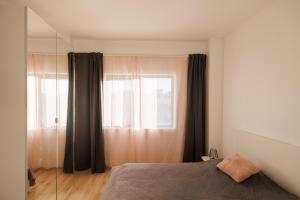 a bedroom with a bed and a large window at FLH - Sunset Horizon near Shopping City with parking in Şelimbăr