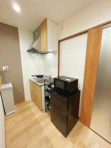 a small kitchen with a microwave and a stove at K-House in Tokyo