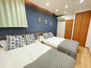 two beds sitting next to each other in a bedroom at K-House in Tokyo