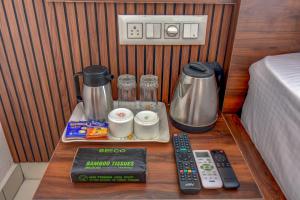 a small table with a coffee maker and remote controls at AVN Comforts Mysore in Mysore