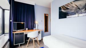 ein Schlafzimmer mit Schreibtisch, Computer und Bett in der Unterkunft Delta Hotel in Vlaardingen