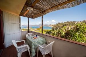 a table and chairs on a balcony with a view of the ocean at Residence Capobianco in Portoferraio