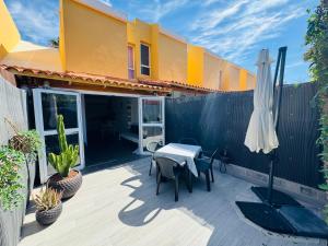 a patio with a table and chairs and an umbrella at Bungalow Casita in Maspalomas