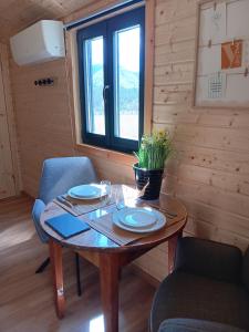 a wooden table with plates and a potted plant on it at La roulotte des foins in Montmaur