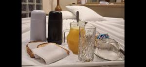 a tray with bread and drinks on a bed at Motel Marajas Mococa - Apartamento 03 in Mococa