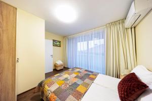 a bedroom with a bed and a large window at Вила "Люляк" in Lakarevo