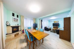 a living room with a wooden table and a fireplace at Вила "Люляк" in Lakarevo