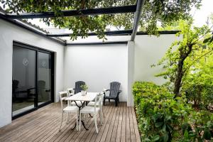 a patio with a table and chairs on a deck at Brenaissance Wine & Stud Estate in Stellenbosch