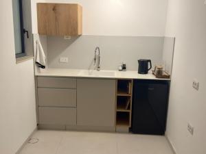 a small kitchen with a sink and a counter at michal Cozy Garden Unit & Jacuzzi in Kammon +12 photos