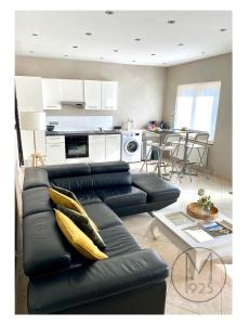 a living room with a black couch and a table at Maison 1925, Méricourt 62 in Méricourt +9 photos