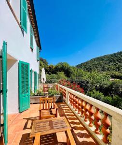 a balcony with two wooden benches and a table at Le Manoir de Port-Cros in Port-Cros