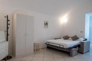 a bedroom with a bed and a white wall at Casa trani in Ischia