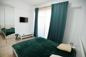 a bedroom with a green bed and a mirror at FLH - Sunset Horizon near Shopping City with parking in Şelimbăr