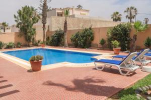 a swimming pool with two lounge chairs next to a house at Spacious 3 bed 2 bath villa with Garden and Pool in Mirleft